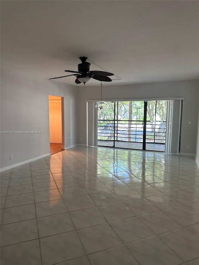 tiled spare room with ceiling fan