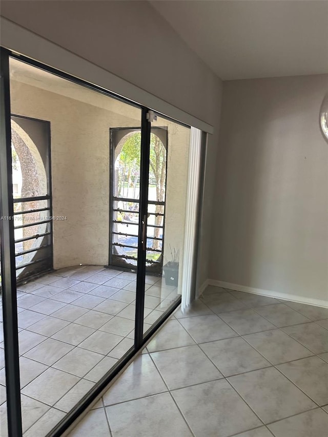 empty room featuring light tile patterned flooring and french doors