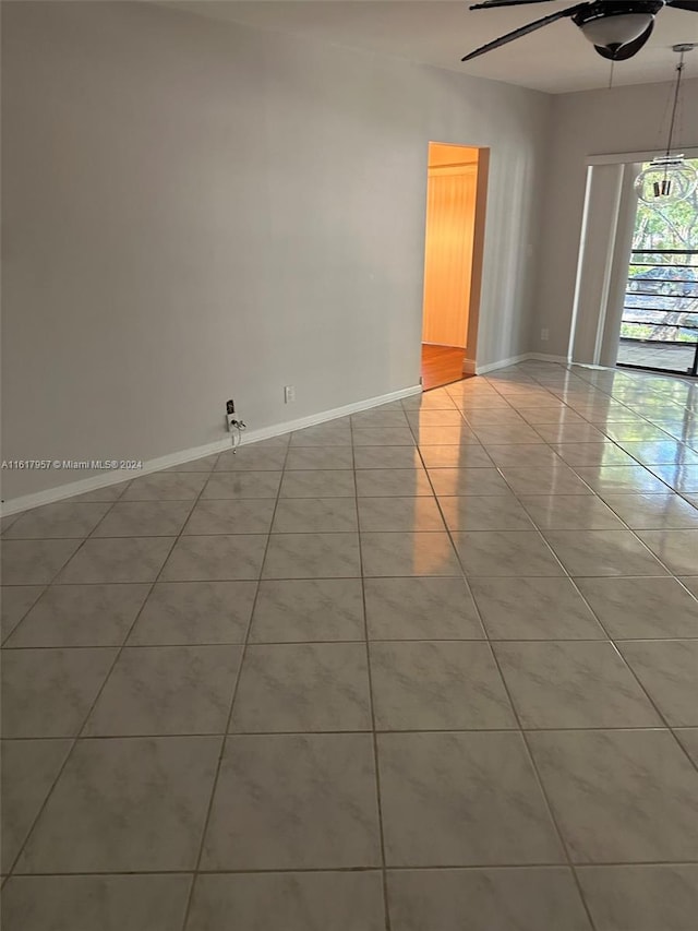 tiled spare room featuring ceiling fan