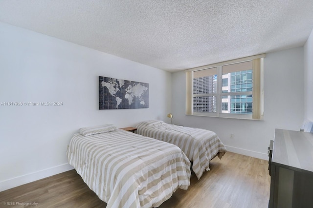 bedroom featuring hardwood / wood-style floors and a textured ceiling