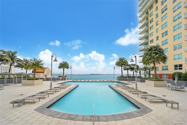 view of pool with a patio area and a water view