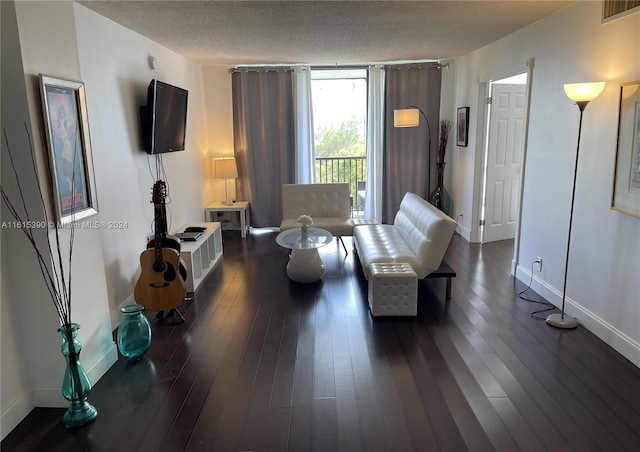 living room featuring dark hardwood / wood-style flooring and a textured ceiling