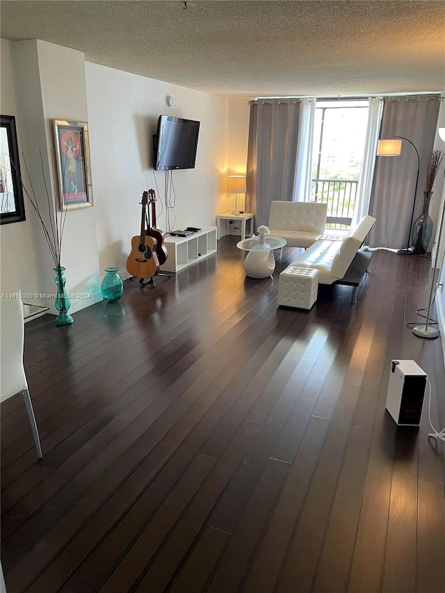 living room featuring a textured ceiling and dark hardwood / wood-style flooring