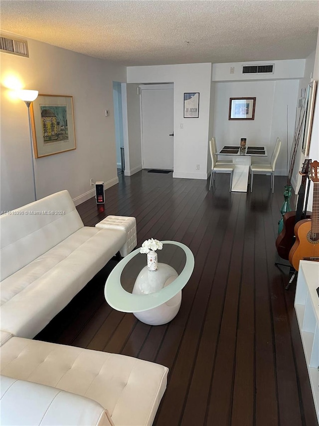 living room with dark wood-type flooring and a textured ceiling