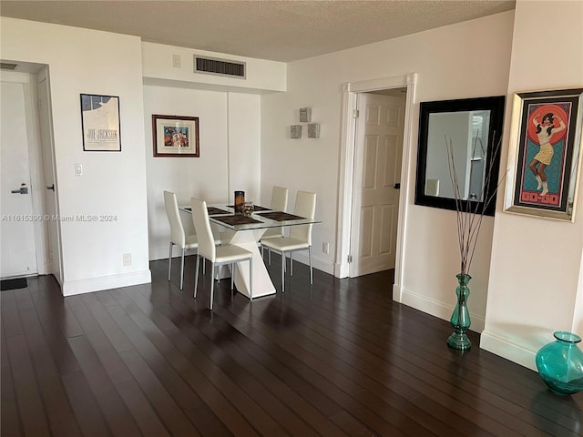 dining area featuring dark hardwood / wood-style floors and a textured ceiling