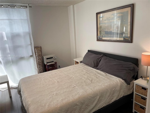 bedroom featuring dark wood-type flooring and a textured ceiling