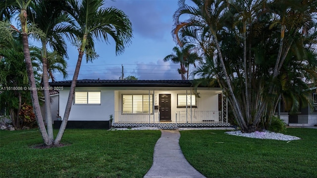 ranch-style house with covered porch and a front lawn