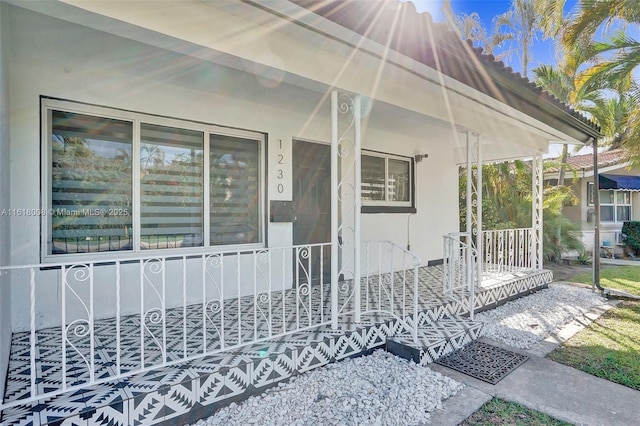 view of exterior entry featuring covered porch