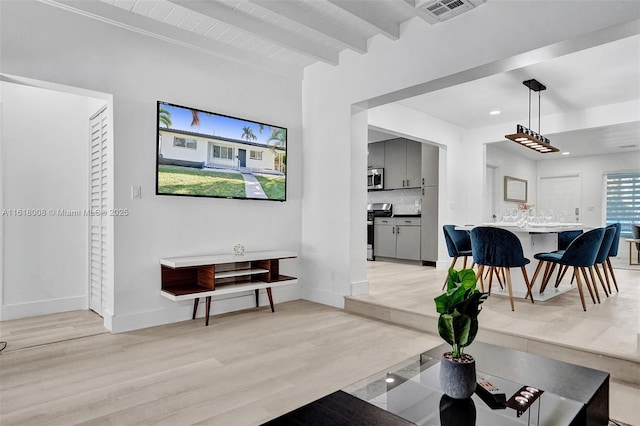 living room with light hardwood / wood-style flooring and beamed ceiling