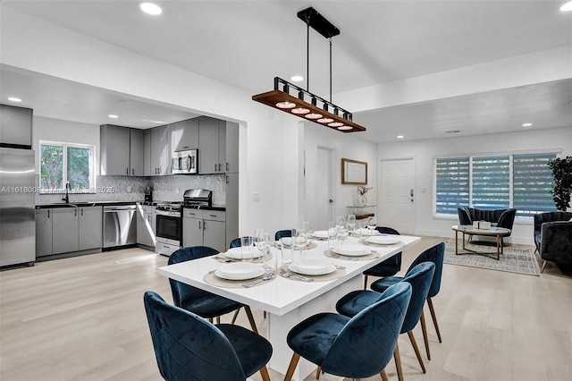 dining room featuring sink and light wood-type flooring