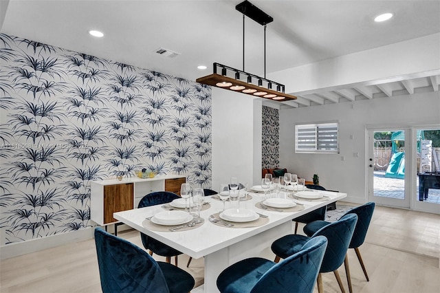 dining space featuring beam ceiling and light hardwood / wood-style floors