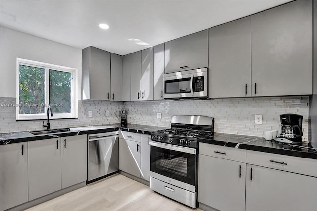 kitchen featuring stainless steel appliances, sink, and backsplash