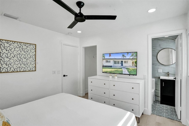 bedroom with sink, connected bathroom, ceiling fan, and light hardwood / wood-style flooring