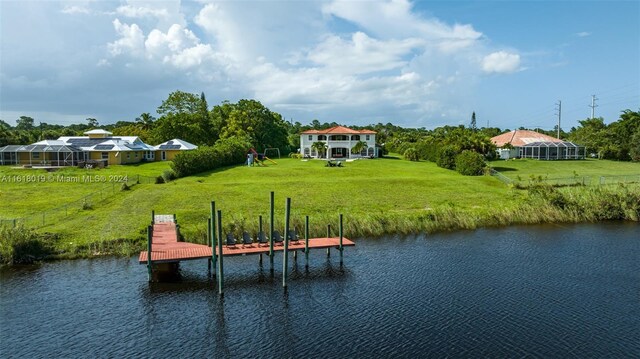 view of dock with a water view and a lawn