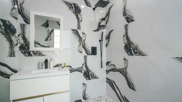 bathroom featuring vanity and tile walls