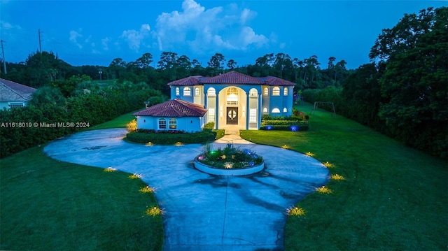 mediterranean / spanish home with a front yard