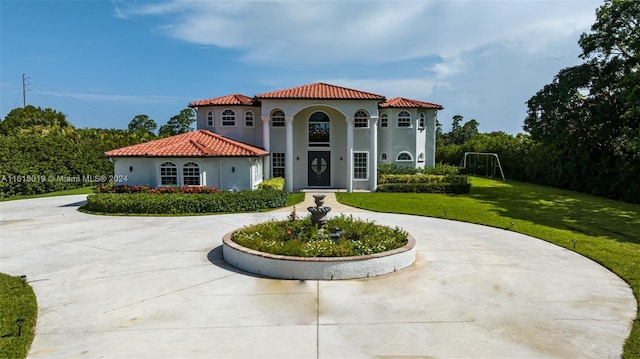 mediterranean / spanish-style home featuring a front lawn