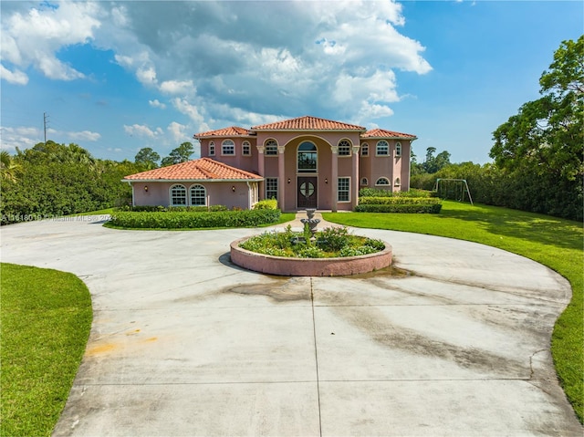 mediterranean / spanish home featuring a front yard