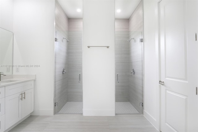 bathroom featuring vanity and a shower with door