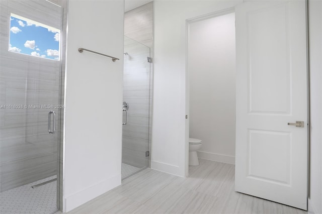 bathroom featuring walk in shower and toilet