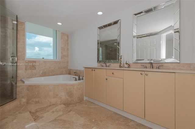 bathroom with vanity and shower with separate bathtub