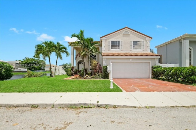 view of front of house with an attached garage, a tiled roof, driveway, stucco siding, and a front lawn