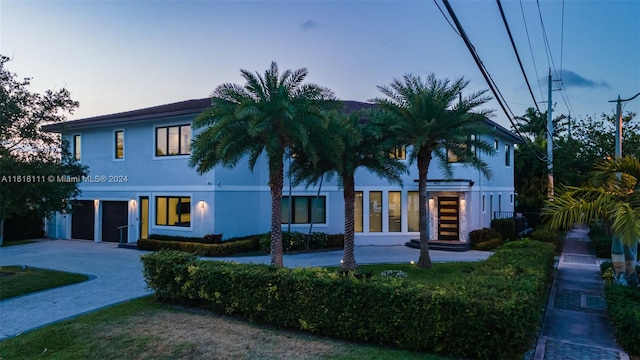 view of front of house featuring a garage and a lawn