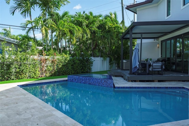 view of swimming pool with a deck and an in ground hot tub