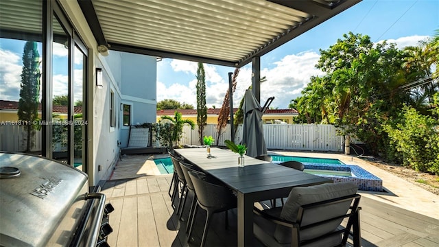 exterior space featuring grilling area and a swimming pool with hot tub