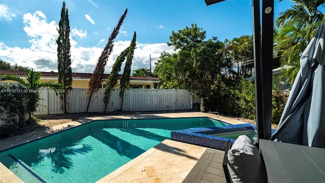 view of swimming pool featuring a patio area and a hot tub