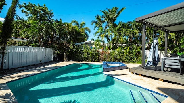 view of swimming pool featuring a deck and a hot tub