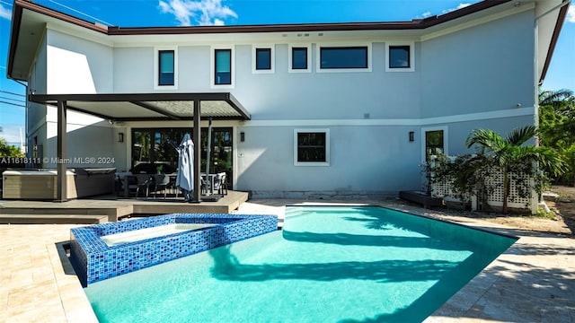 view of pool featuring an in ground hot tub and a patio area