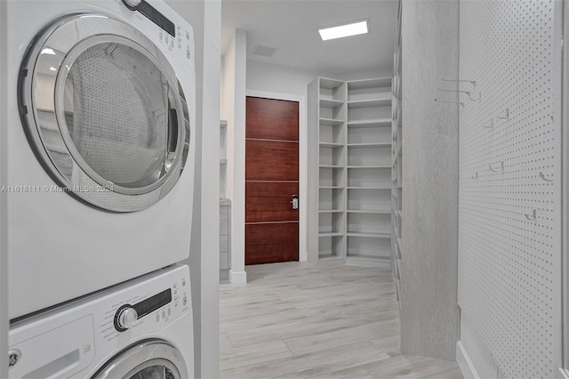 clothes washing area featuring stacked washer and clothes dryer