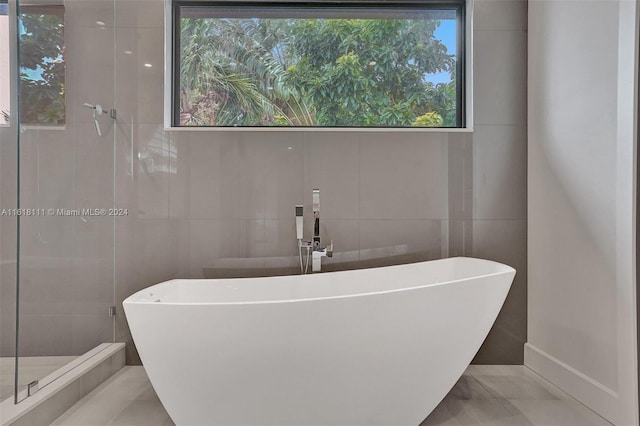 bathroom with tile walls and a tub to relax in