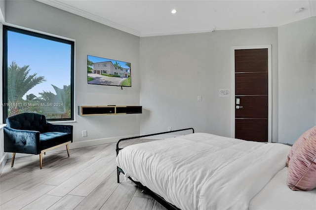 bedroom featuring ornamental molding and light wood-type flooring