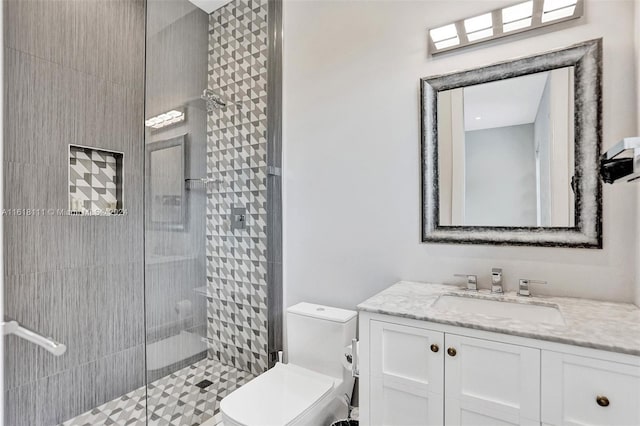 bathroom featuring vanity, tiled shower, and toilet