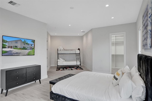 bedroom featuring light hardwood / wood-style flooring and a walk in closet