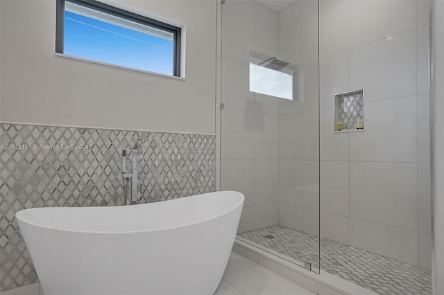 bathroom featuring tile walls, separate shower and tub, and tile patterned floors