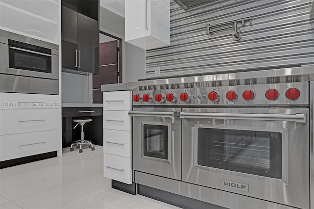 kitchen featuring light tile patterned floors, premium range, and white cabinets