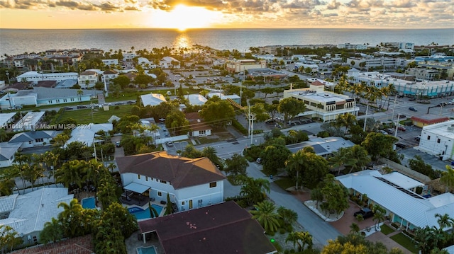 aerial view at dusk featuring a water view