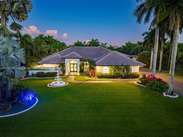 mediterranean / spanish house with a lawn