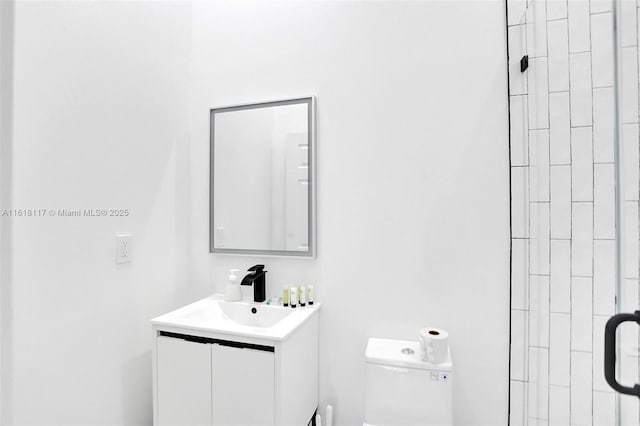 bathroom featuring vanity, an enclosed shower, and toilet