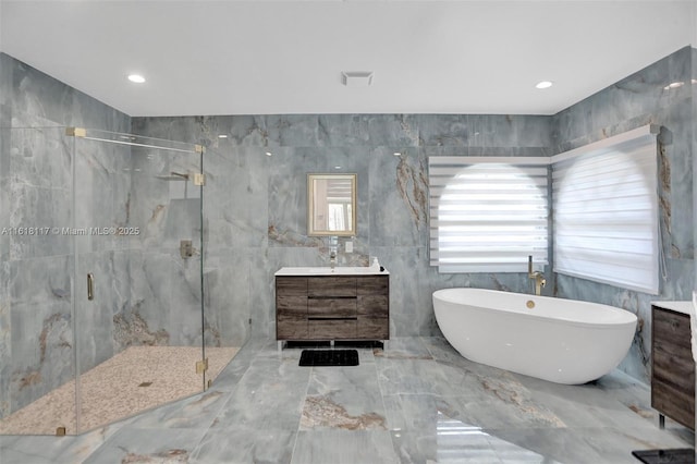 bathroom with plus walk in shower, tile walls, and vanity