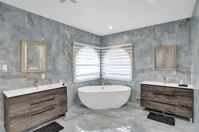 bathroom with vanity, a bathtub, and tile walls