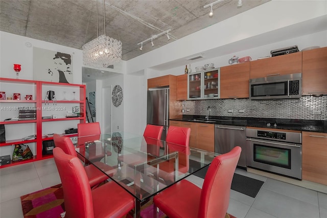 dining room with sink, a chandelier, track lighting, and light tile patterned floors