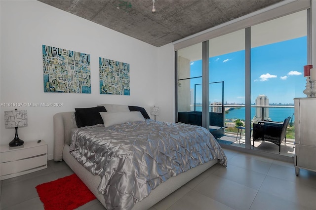 bedroom with a city view, a water view, and floor to ceiling windows