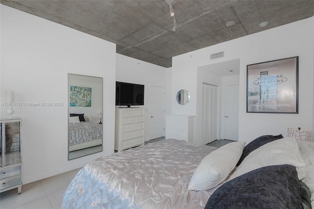 bedroom featuring light tile patterned floors, visible vents, and baseboards