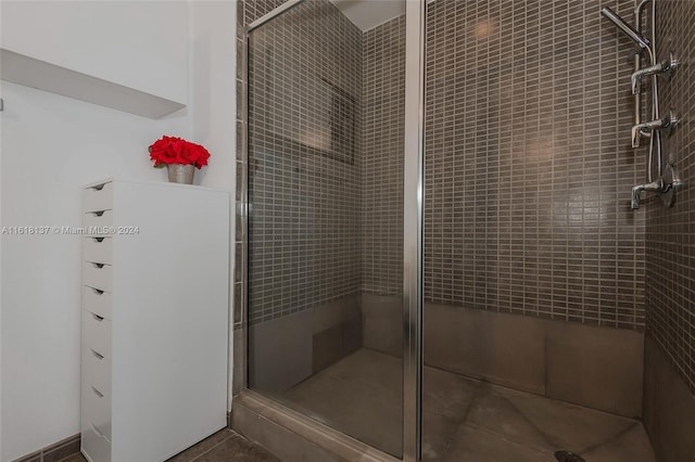 bathroom featuring tile patterned flooring and a shower stall