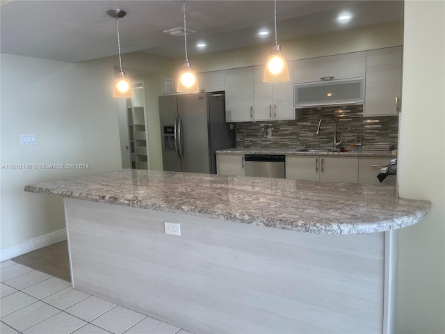 kitchen featuring light tile patterned flooring, backsplash, appliances with stainless steel finishes, pendant lighting, and sink