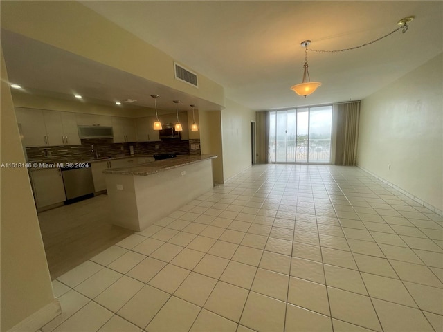 kitchen featuring decorative backsplash, stainless steel appliances, light tile patterned flooring, and hanging light fixtures